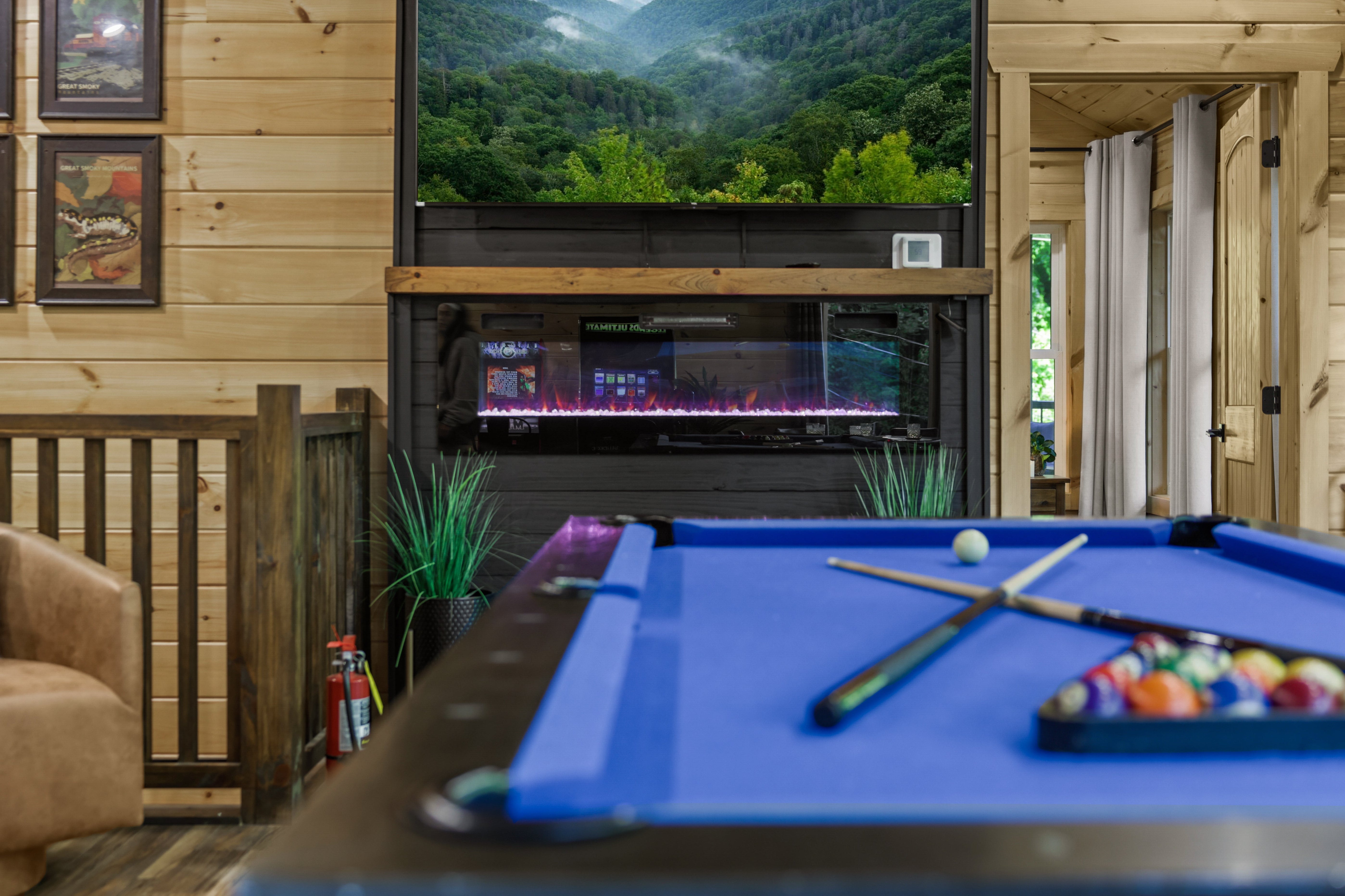 Game room with pool table, fireplace, and mountain view TV